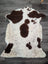 A plush cream and brown tibet highland spotted sheepskin rug with soft fluffy texture measuring 43.5 by 29.5 inches