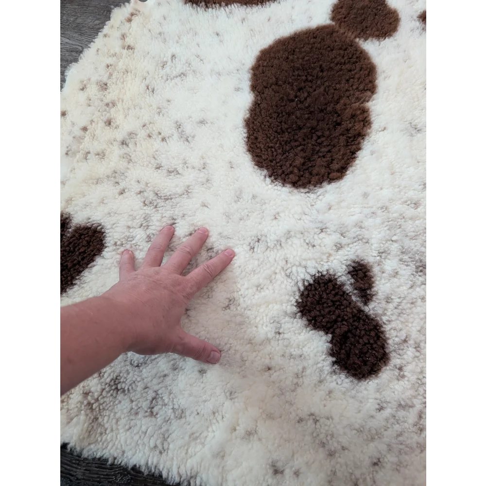 A plush white and brown tibet highland spotted sheepskin rug with a soft textured surface perfect for cozy spaces