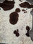 A plush cream-colored tibet highland spotted sheepskin rug with soft brown patches and fuzzy texture measuring 43.5 x 29.5 inches