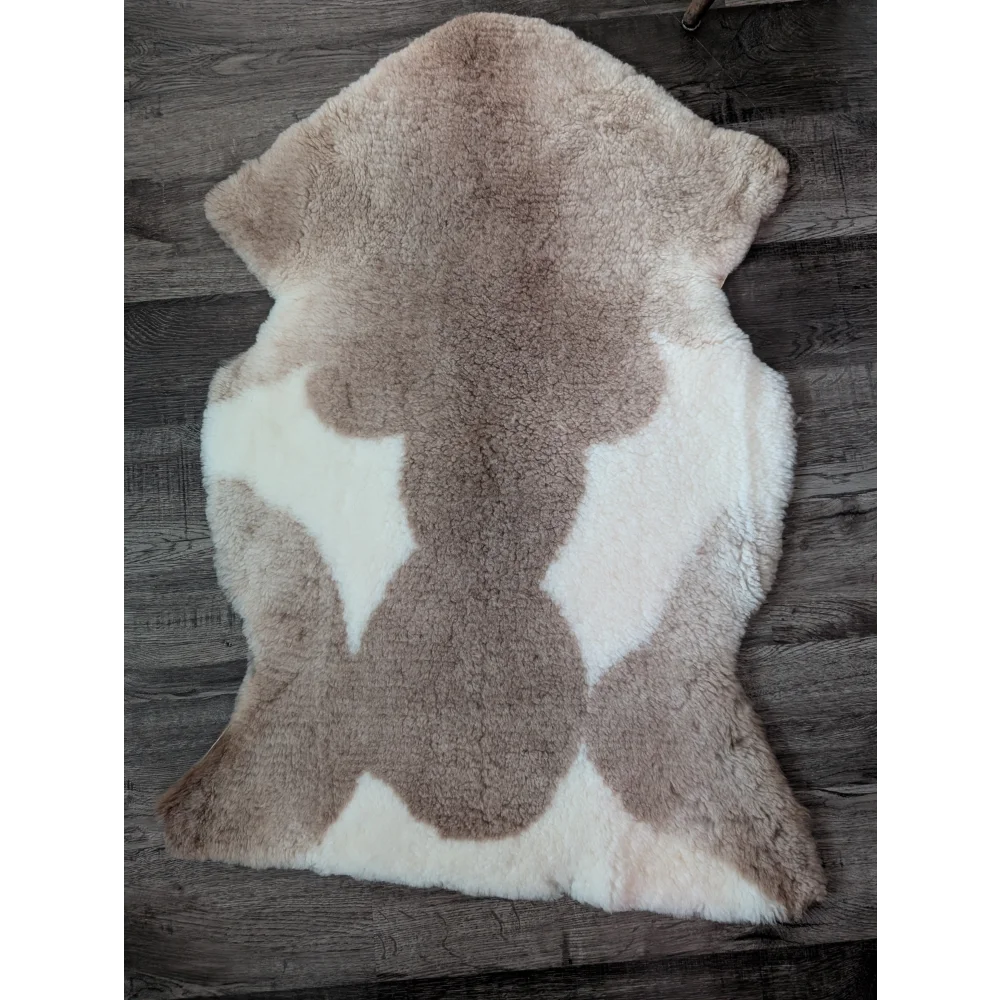 A plush beige and white tibet highland spotted sheepskin rug sized 41 by 25.5 inches grade a quality