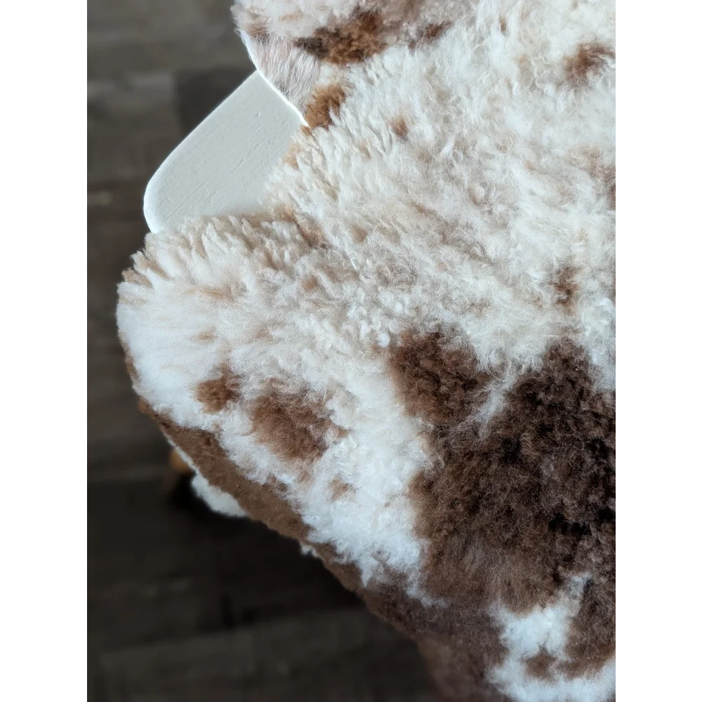 A cream and brown speckled tibet highland spotted sheepskin blanket with soft curly texture 42.5 x 26 grade a