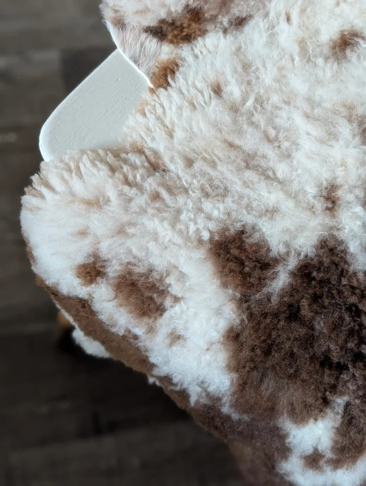 A cream and brown speckled tibet highland spotted sheepskin blanket with soft curly texture 42.5 x 26 grade a
