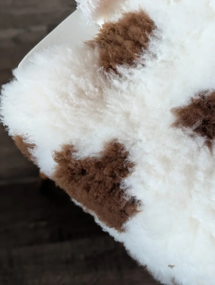 A plush white and brown highland spotted sheepskin throw with soft fluffy texture from tibet highland spotted grade a