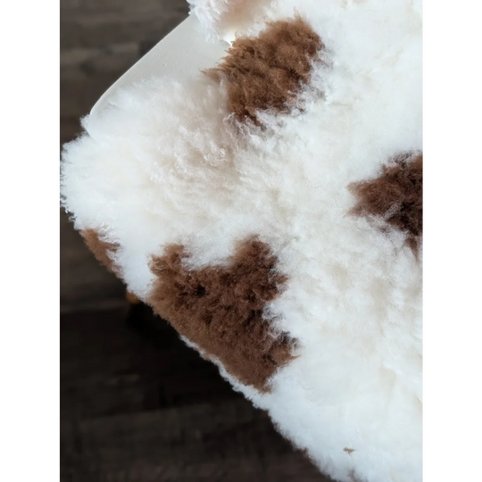 A plush white and brown highland spotted sheepskin throw with soft fluffy texture from tibet highland spotted grade a