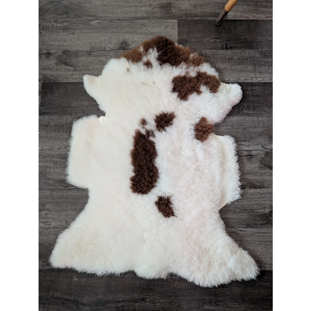 A plush white and brown highland spotted sheepskin rug with soft fluffy texture from tibet highland spotted grade a