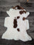 A plush white and brown highland spotted sheepskin rug with soft fluffy texture from tibet highland spotted grade a