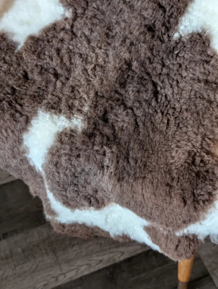 Brown and white tibet highland spotted sheepskin rug with natural fluffy texture perfect for cozy decor