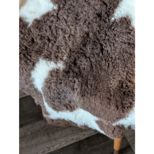 Brown and white tibet highland spotted sheepskin rug with natural fluffy texture perfect for cozy decor