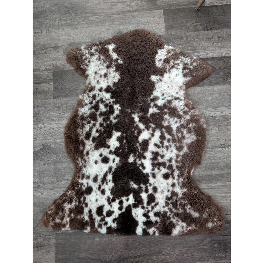 Brown and white tibet highland spotted sheepskin rug with plush natural fur texture sized 40 by 25 inches