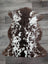Brown and white tibet highland spotted sheepskin rug with plush natural fur texture sized 40 by 25 inches