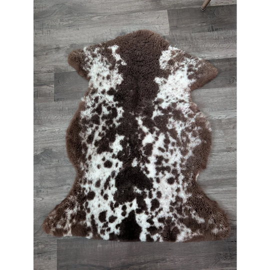 Brown and white tibet highland spotted sheepskin rug with plush natural fur texture sized 40 by 25 inches