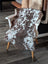 Brown and white tibet highland spotted sheepskin throw draped over a white wooden chair for cozy decor