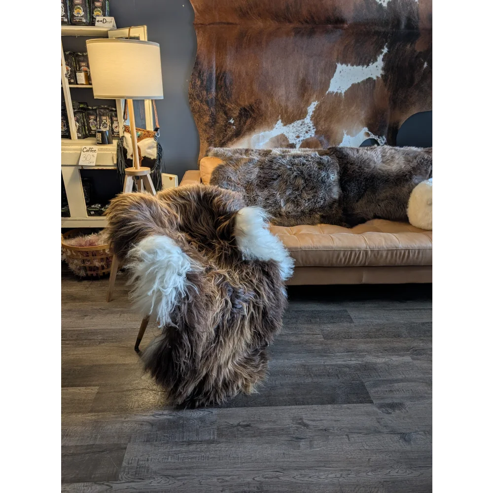 A plush brown and white sheepskin chair made of long wool icelandic with a soft fluffy texture in natural bronze color