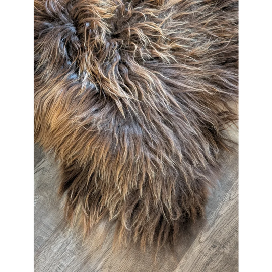 A plush shaggy brown and tan long wool icelandic sheepskin rug with a soft textured surface natural bronze color