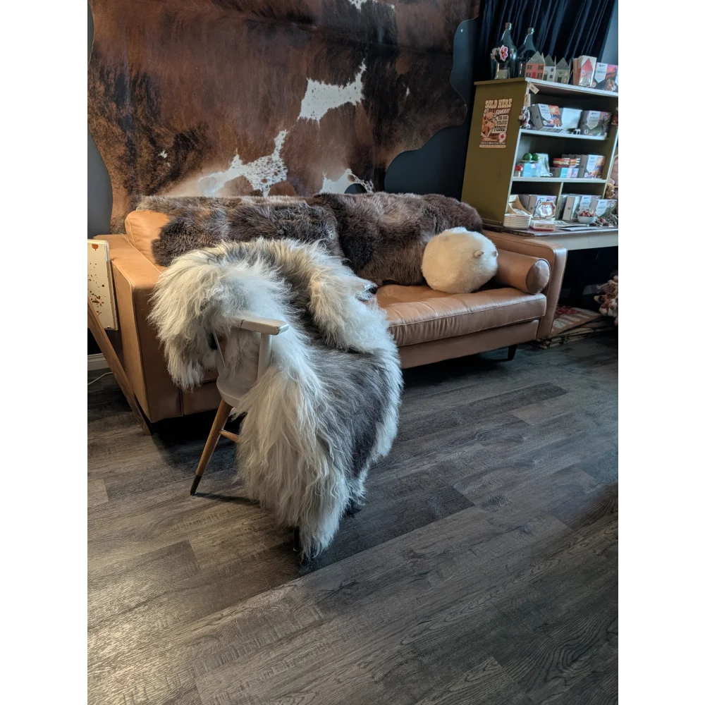 Thick fluffy white and gray icelandic sheepskin rug draped over wooden chair long wool icelandic natural grey