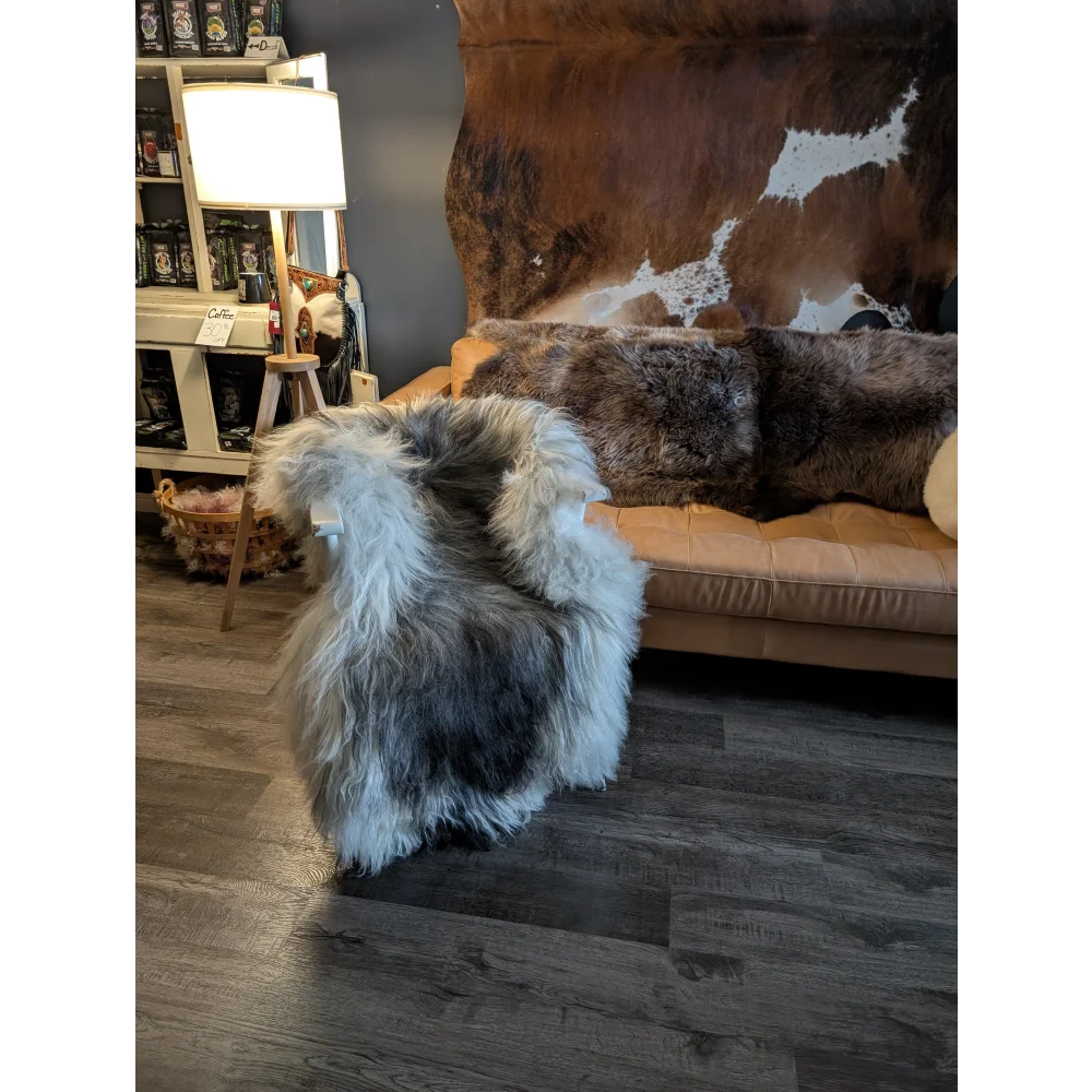 A plush icelandic sheepskin throw with natural grey long wool icelandic fur draped over an upholstered chair back