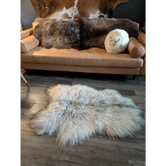 Fluffy natural grey icelandic sheepskin rug with long wool icelandic fibers spread on wooden floor 55 x 35 inches