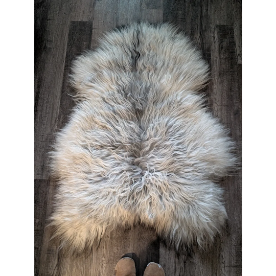 A fluffy natural grey icelandic sheepskin rug with long wool icelandic texture measuring 55 by 35 inches
