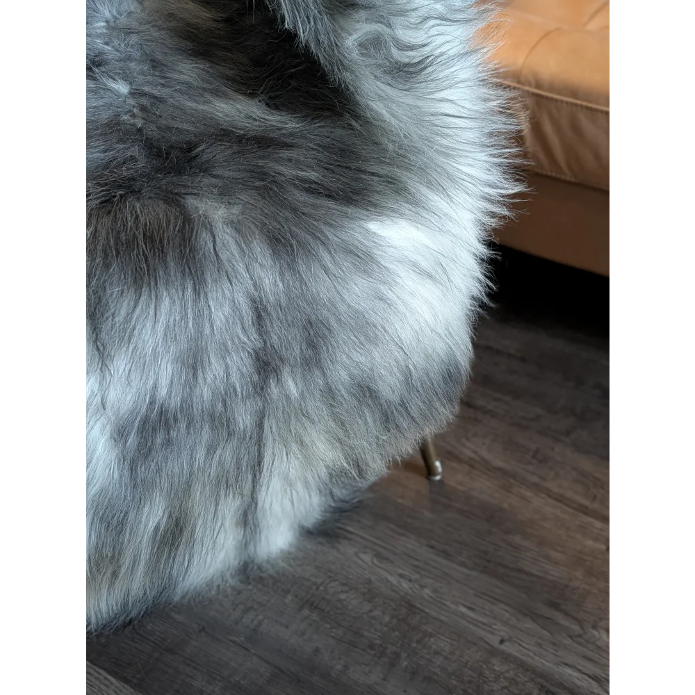 A plush gray and white wool icelandic faux fur throw blanket with a soft fluffy texture 54 by 33 inches