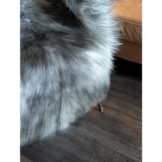 A plush gray and white wool icelandic faux fur throw blanket with a soft fluffy texture 54 by 33 inches