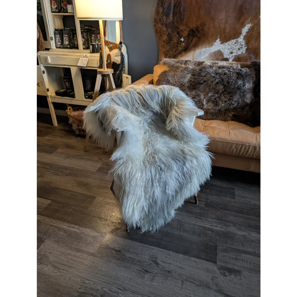 A plush white wool icelandic sheepskin throw draped over a chair perfect for cozy home decor