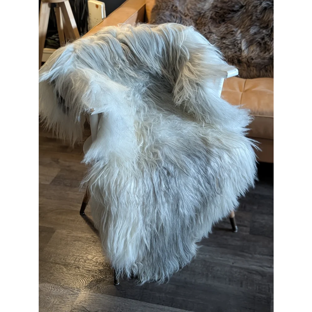 A plush white wool icelandic sheepskin throw draped over a chair in natural grey double icelandic style