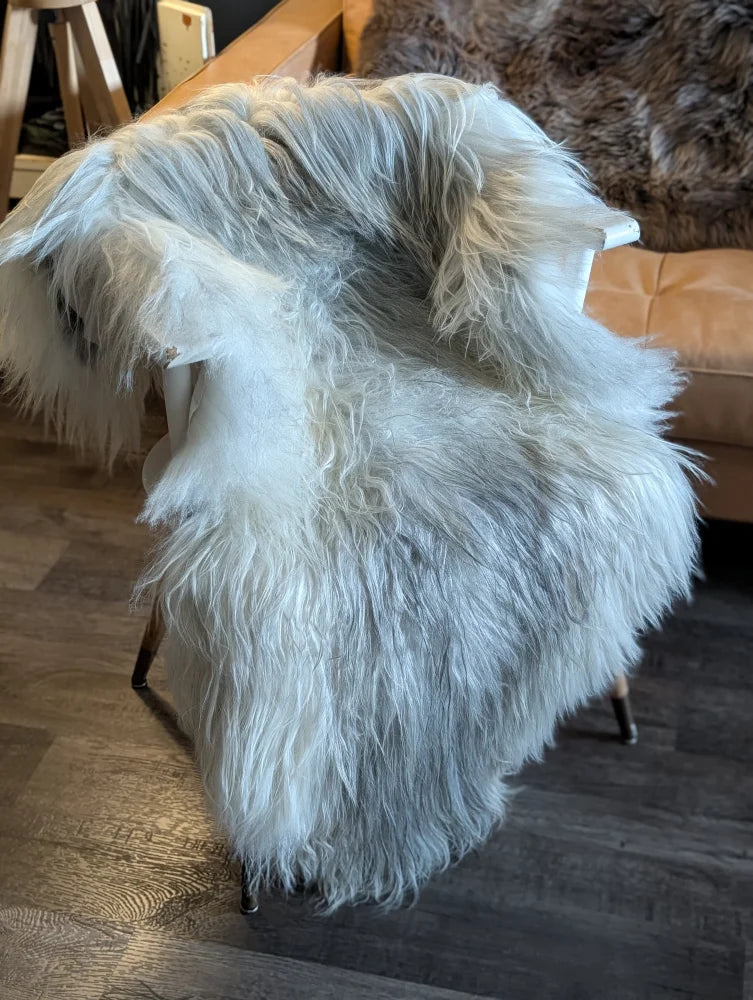 A plush white wool icelandic sheepskin throw draped over a chair in natural grey double icelandic style