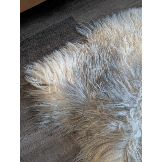A soft double icelandic sheepskin rug in natural grey with cream and gray tones measuring 57 by 35 inches