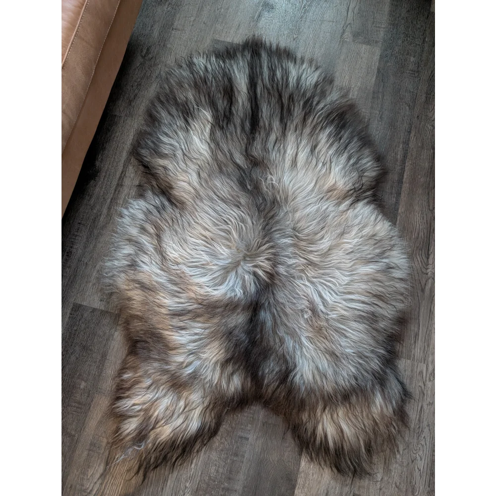 A plush wool icelandic sheepskin rug in natural grey with gray black and brown shades measuring 54 by 34 inches