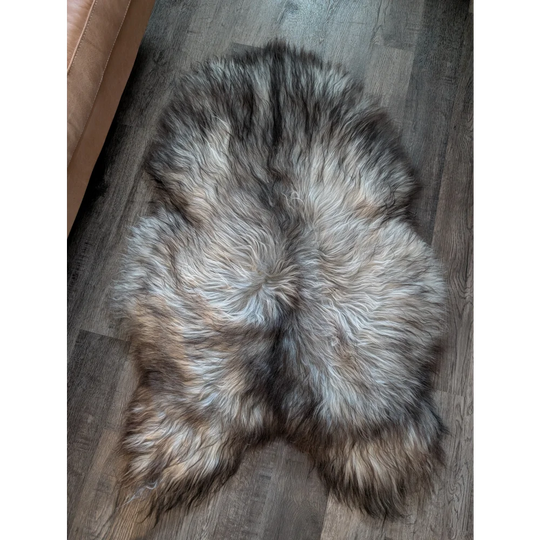 A plush wool icelandic sheepskin rug in natural grey with gray black and brown shades measuring 54 by 34 inches