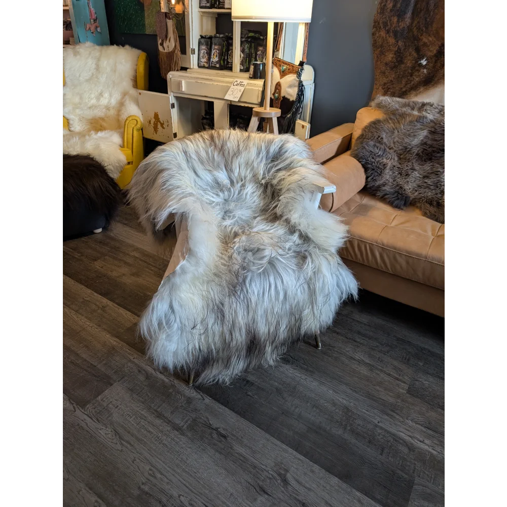 A plush 57 x 37 inch massive icelandic sheepskin throw in natural grey wool icelandic draped over a chair