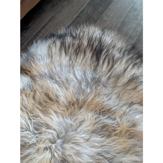 A fluffy double icelandic sheepskin rug with natural grey cream and black wool icelandic texture measuring 57 by 37 inches