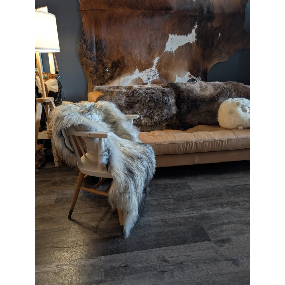 Beige leather sofa with thick fluffy brown and white fur throws featuring double icelandic sheepskin wool natural grey