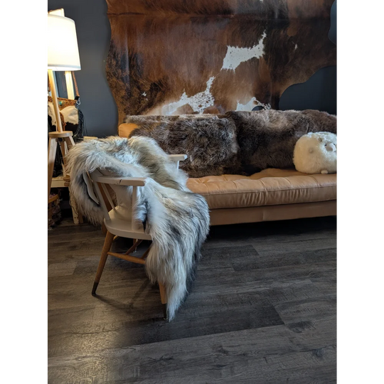 Beige leather sofa with thick fluffy brown and white fur throws featuring double icelandic sheepskin wool natural grey