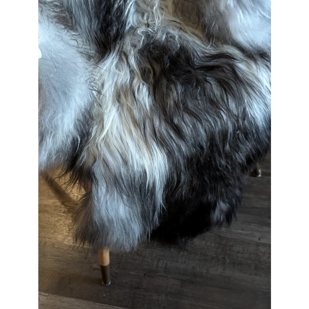 A plush long-haired wool icelandic faux fur throw in black white and subtle gray tones measuring 56 x 36 inches