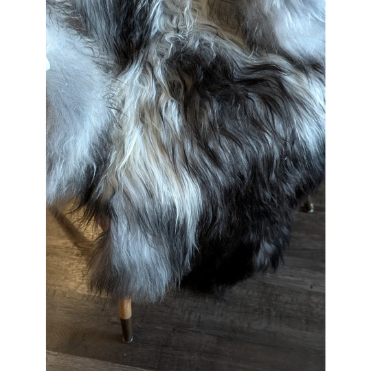 A plush long-haired wool icelandic faux fur throw in black white and subtle gray tones measuring 56 x 36 inches