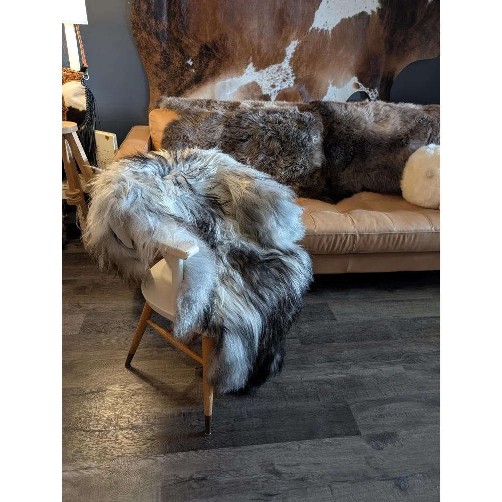 A plush double icelandic sheepskin throw in natural grey wool icelandic draped over a light wood chair