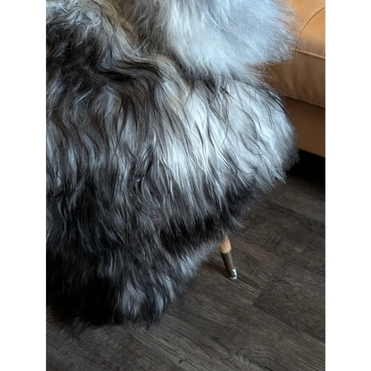 A plush long-haired natural grey icelandic sheepskin wool draped over a chair leg showing thick double icelandic texture
