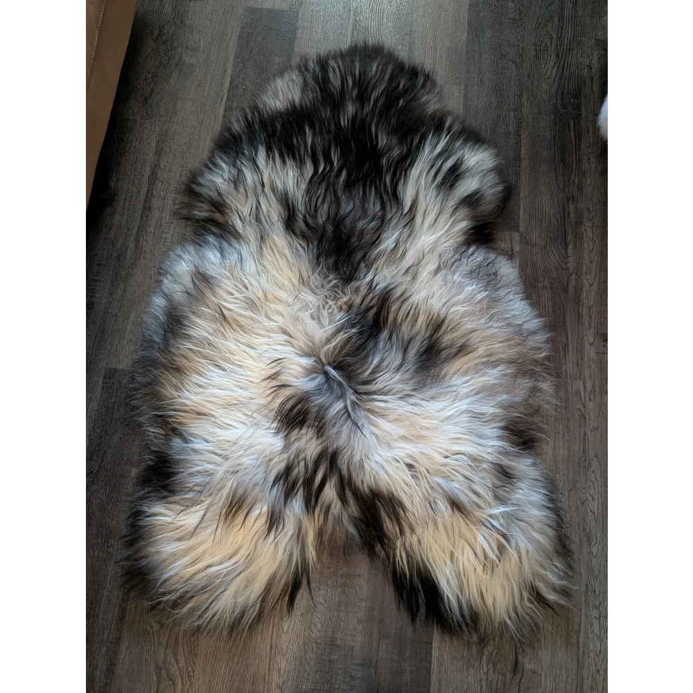 A plush, naturally colored double icelandic sheepskin rug in black, gray, and cream wool icelandic fur, 56 by 36 inches