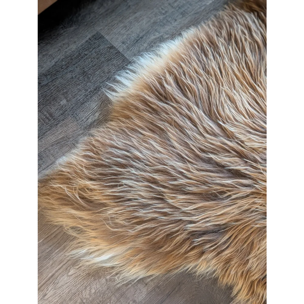 A plush long wool icelandic sheepskin rug in natural bronze tan and white measuring 58 by 34 inches