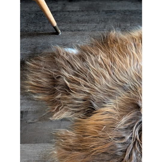 A plush 60 x 34 inch long wool icelandic sheepskin rug in natural bronze with soft shaggy faux fur texture