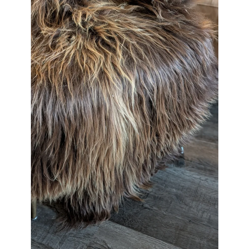 A plush long wool icelandic brown and tan ottoman with soft shaggy faux fur in natural bronze color