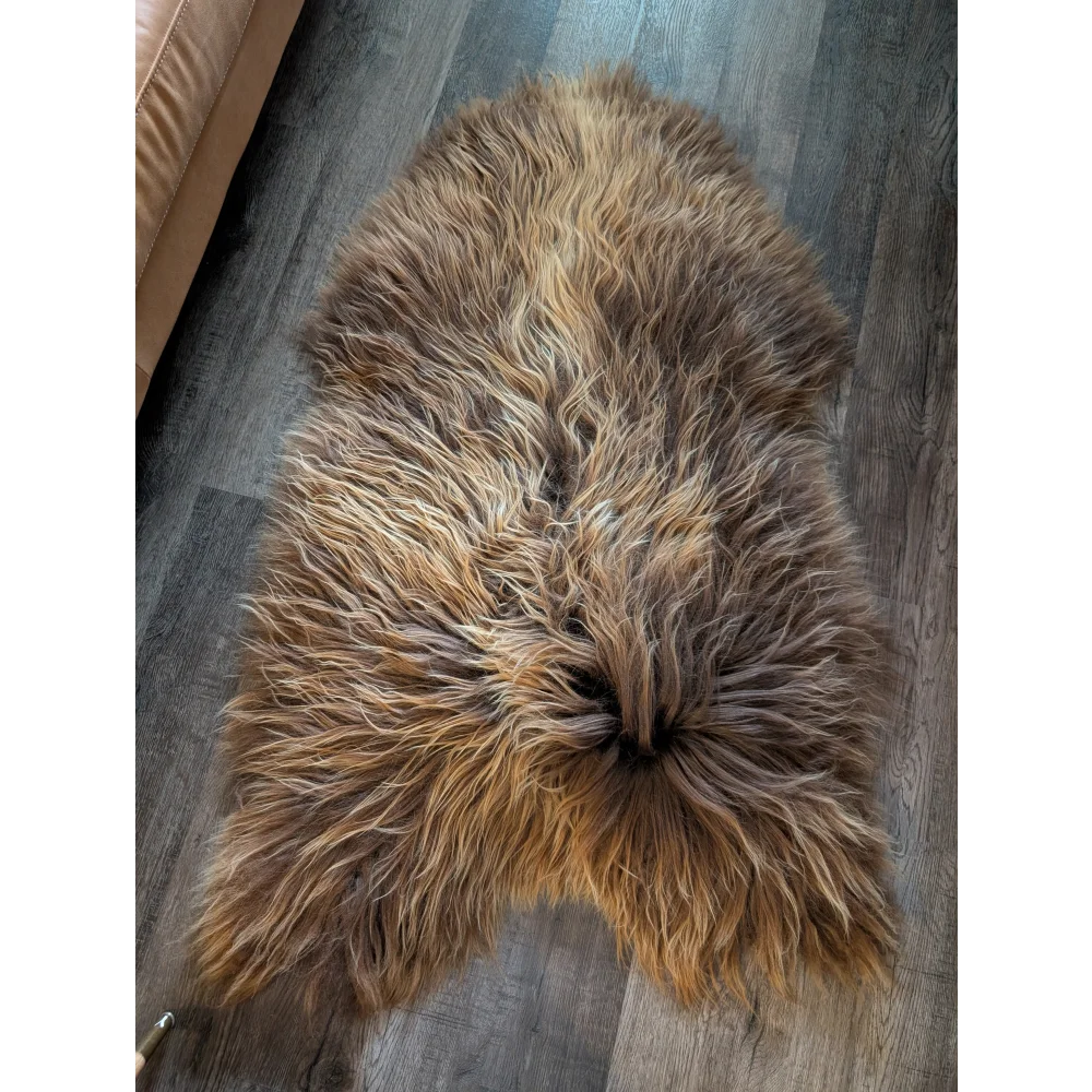 A plush icelandic sheepskin rug with long wool icelandic texture in natural bronze brown and tan tones, 59 by 33 inches