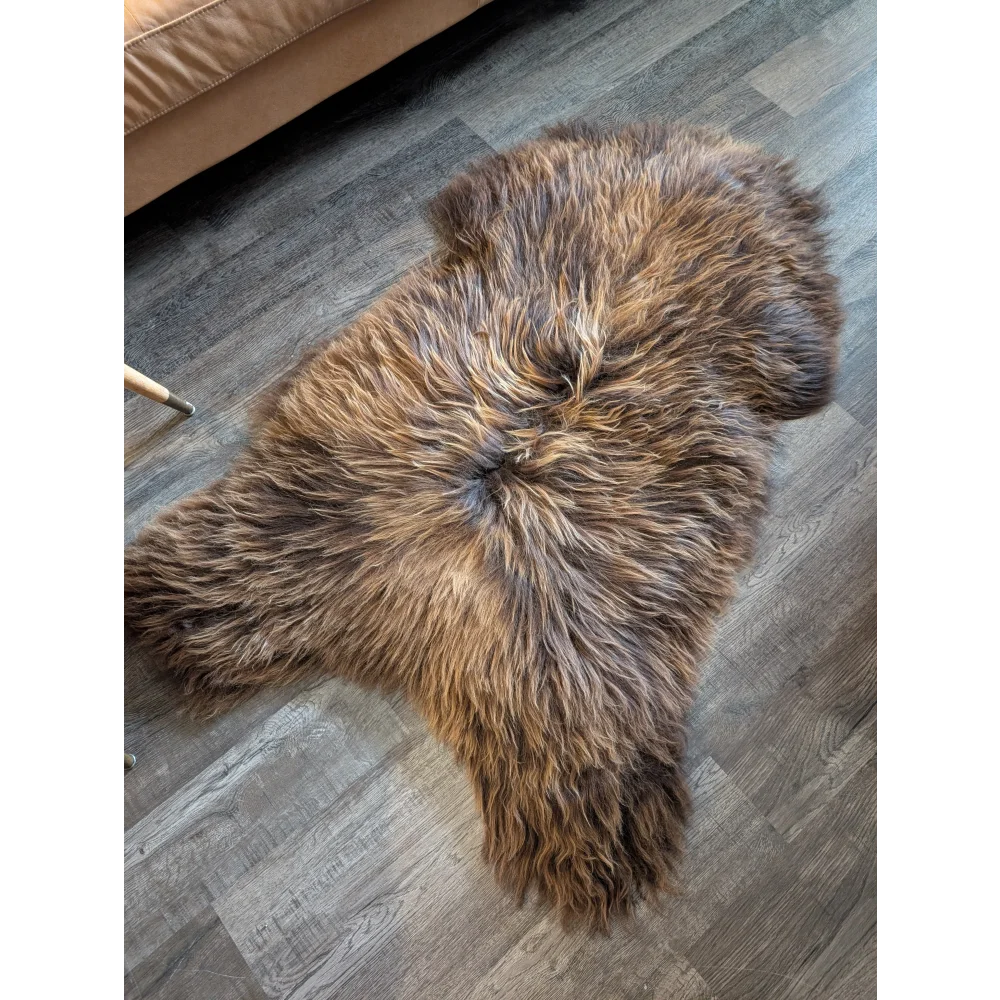 A plush 57 by 32 inch natural bronze icelandic sheepskin rug with soft long wool icelandic texture and irregular edges