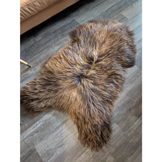 A plush 57 by 32 inch natural bronze icelandic sheepskin rug with soft long wool icelandic texture and irregular edges