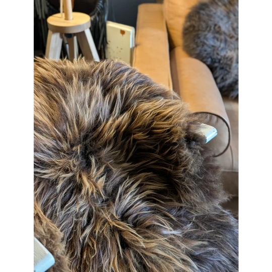 A plush shaggy brown and beige long wool icelandic throw blanket with a soft textured surface perfect for cozying up