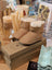 Tan sheepskin baby booties with fur lining on boxes
