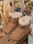 Cute tan UGG sheepskin baby booties with fur lining, ten pairs
