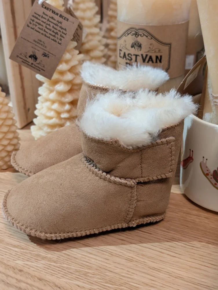 Tan sheepskin baby booties with cozy fur lining and label tag