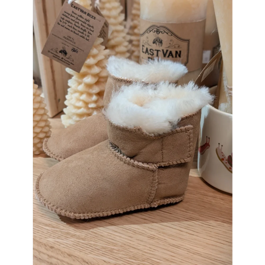 Tan sheepskin baby booties with cozy fur lining and label tag